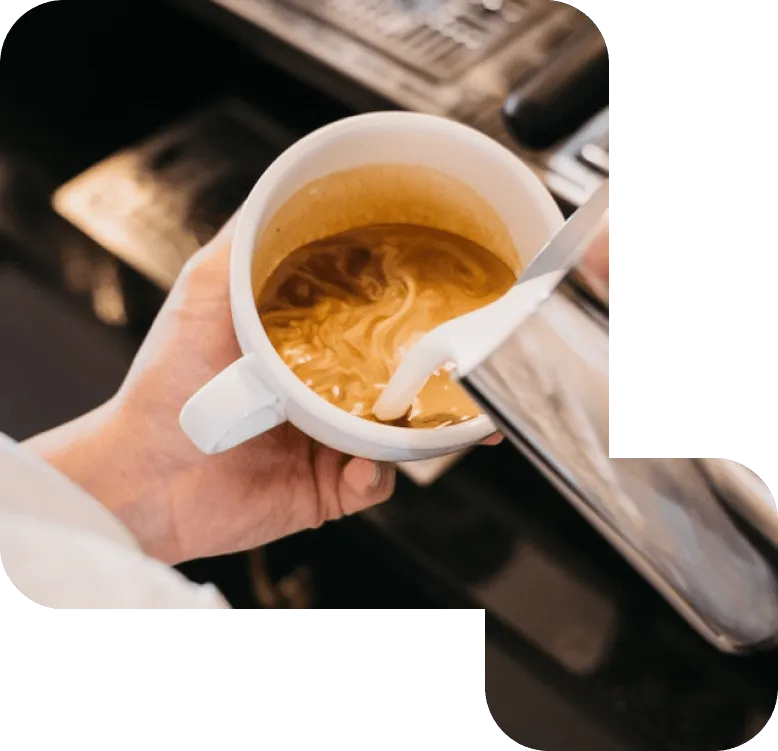 Mjölk hälls i en kopp kaffe