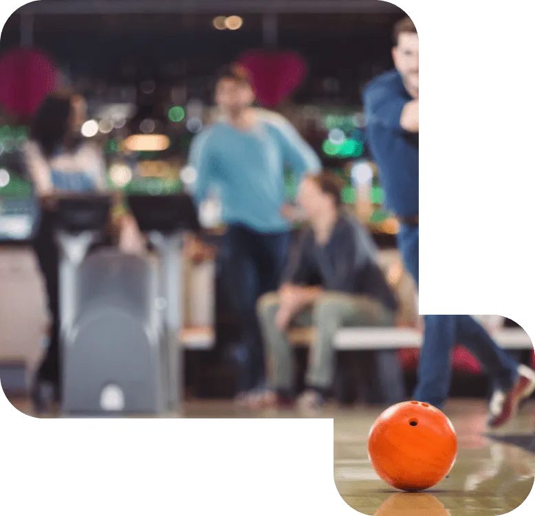Orange bowlingklot kastas på en bowlingbana