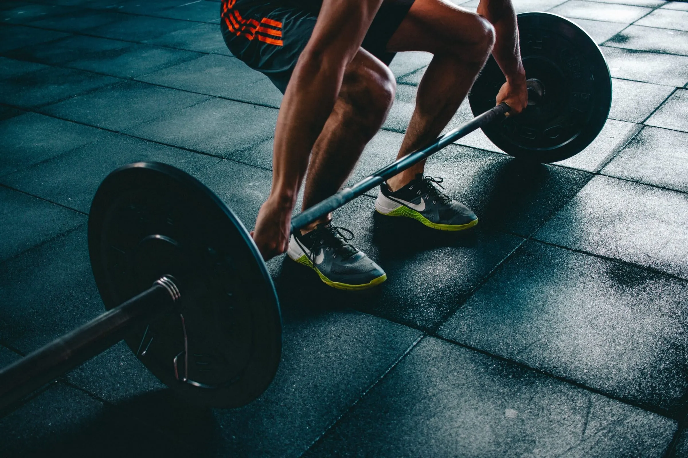 Man ska lyfta en skivstång på ett träningscenter